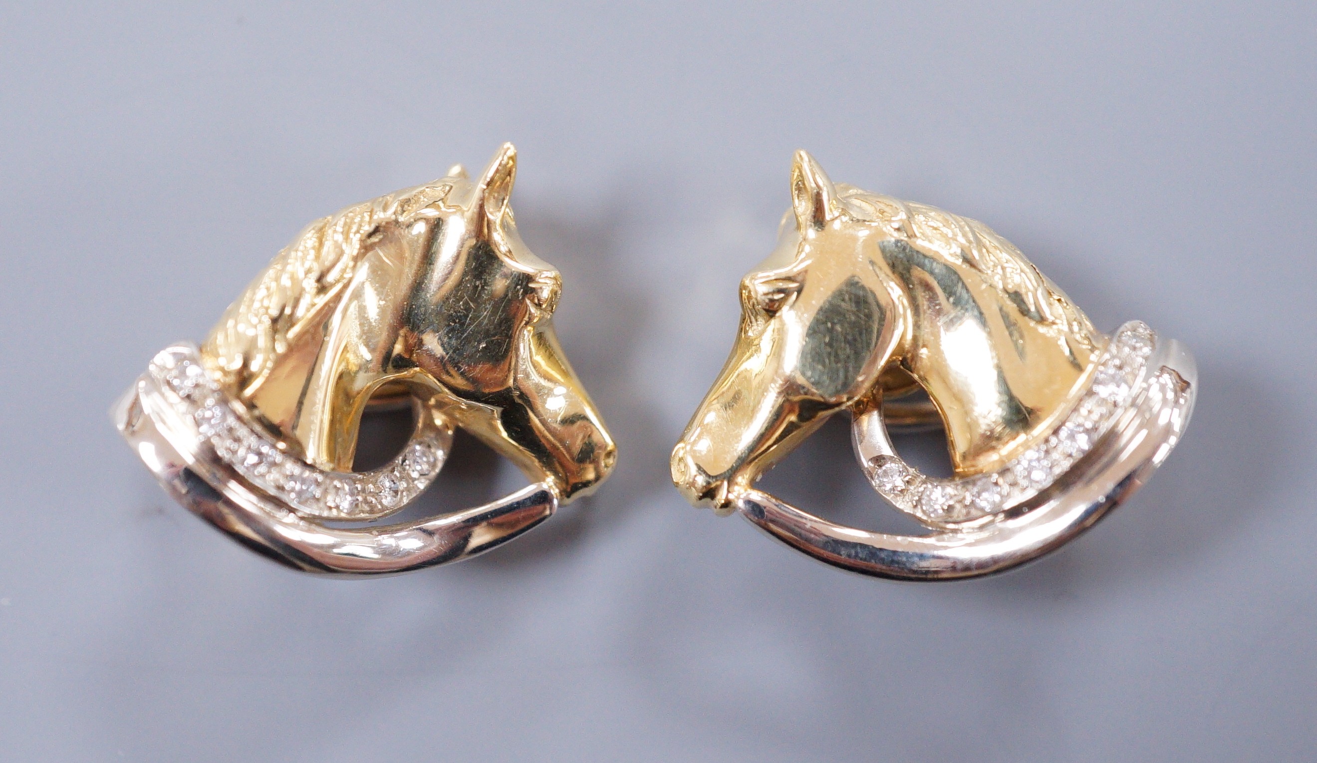 A pair of diamond set 18ct gold horse head ear clips, 2cm, gross 9.8 grams